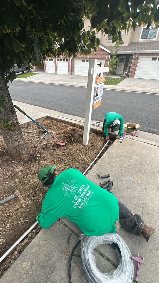Crew installing irrigation lines by a sidewalk