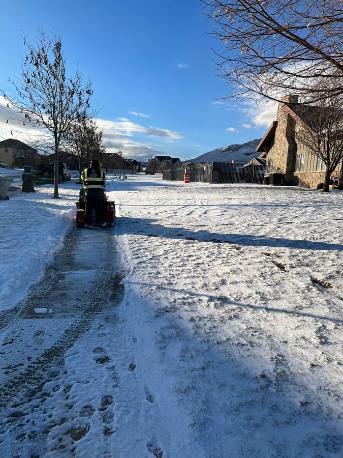 Ride-on machine clearing an icy sidewalk